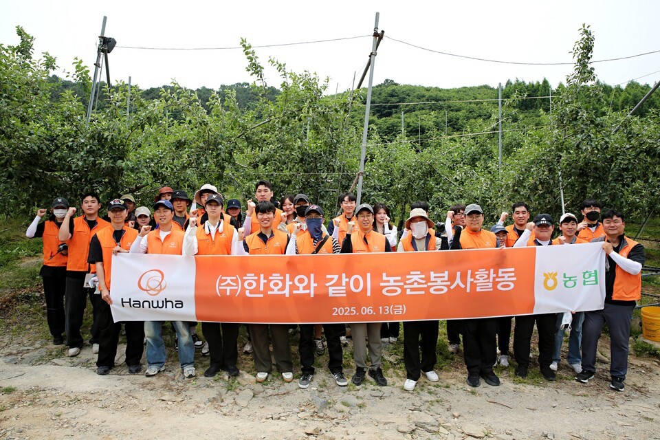 ㈜한화 임직원들이 경기도 연천군 군남면 임진농협 관내 사과농가에서 농촌 일손돕기 봉사활동을 진행한 뒤 기념사진을 촬영하고 있다