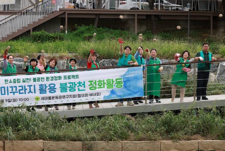 Saemaeul Movement Eunpyeong District and Mayor Kim Mi-kyung (second from right) throwing soil balls into Bulkwangcheon