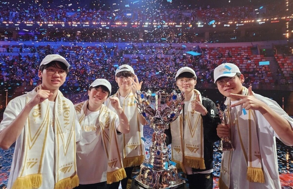 T1 players celebrate with the 2025 Worlds trophy, taking a commemorative photo