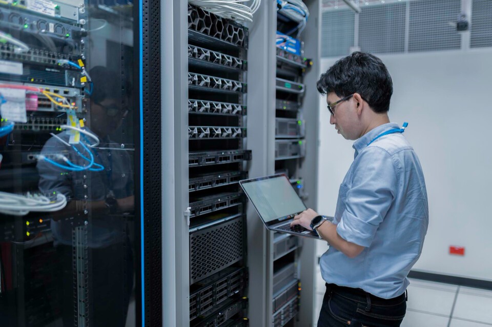 データセンターサーバーをチェックするエンジニアの姿