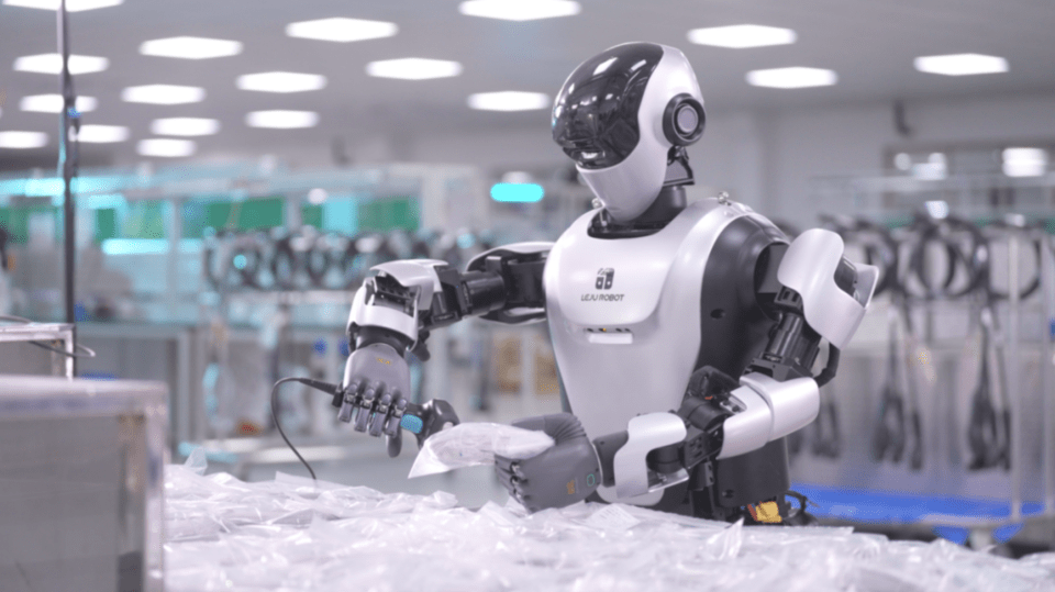 ヒューマノイドロボットが作業現場で物体を持ち上げ整理している