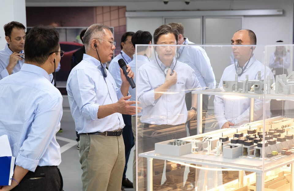 鄭義宣会長が塗装工場の模型の前で、現代自動車のトルコ工場の従業員らと塗装品質について話している。(写真=現代自動車提供)
